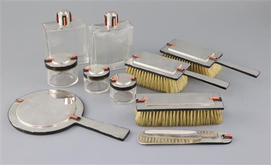 A George V Cartier Ltd Art Deco ten piece silver, coral and black enamel mounted dressing table set, mirror 22.7cm.